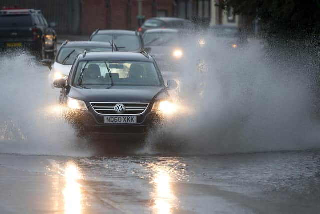 A car drives through a flooded road  (Photo by Matthew Horwood/Getty Images)