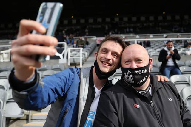 Newcastle fans wearing protective face coverings to combat the spread of the coronavirus, take a selfie photograph as they take their seats for the English Premier League football match between Newcastle United and Sheffield United at St James' Park in Newcastle-upon-Tyne, north east England on May 19, 2021: CARL RECINE/POOL/AFP via Getty Images