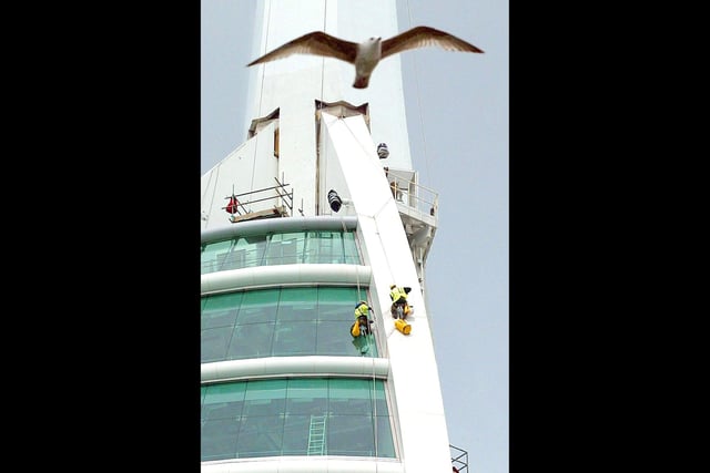 High access workers Steve Collins and Olly Laker cleaning the glass on the outside of the viewing gallery of the Spinnaker Tower. Picture: Chris Ison/PA