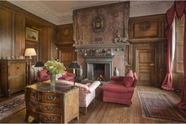 With its carved fireplace and elaborate wood panelling, the drawing room in this historical castle is a lovely space in which to entertain guests.