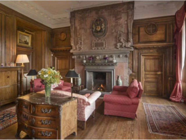 With its carved fireplace and elaborate wood panelling, the drawing room in this historical castle is a lovely space in which to entertain guests.