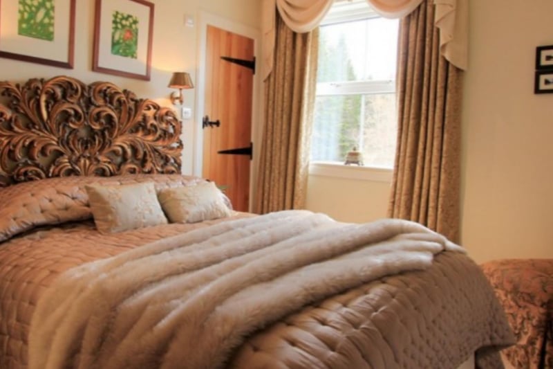 The double bedroom has an ensuite shower room and a dramatic carved headboard.