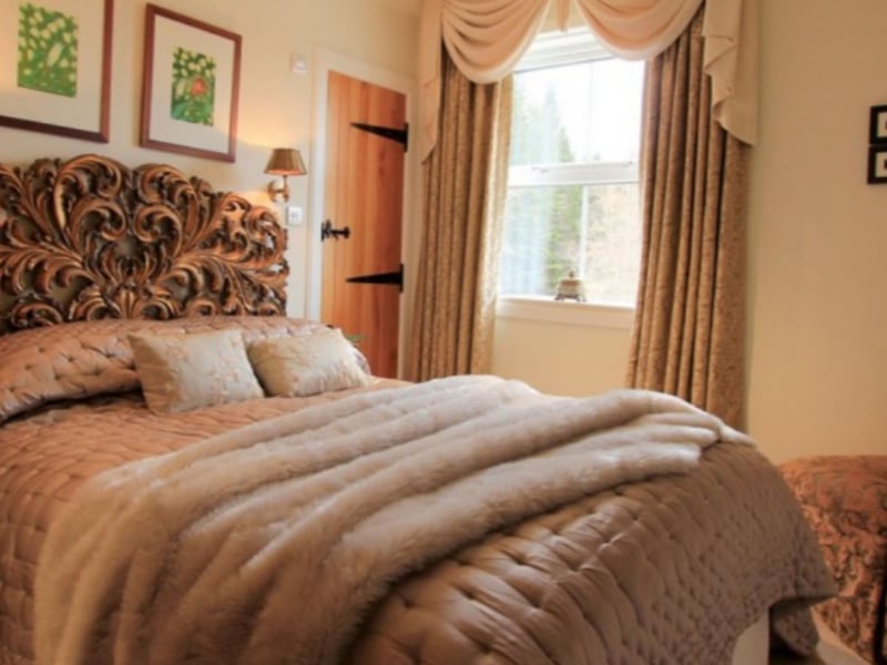 The double bedroom has an ensuite shower room and a dramatic carved headboard.