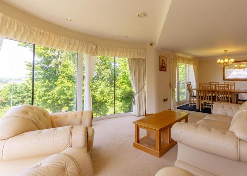 The classy main reception and dining room on the first floor. A panoramic, curved window offers stunning views, while there is ample space to entertain guests, and also a Juliet balcony.