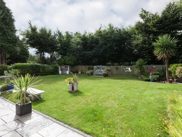 The garden is fully enclosed by fencing and stone walling.