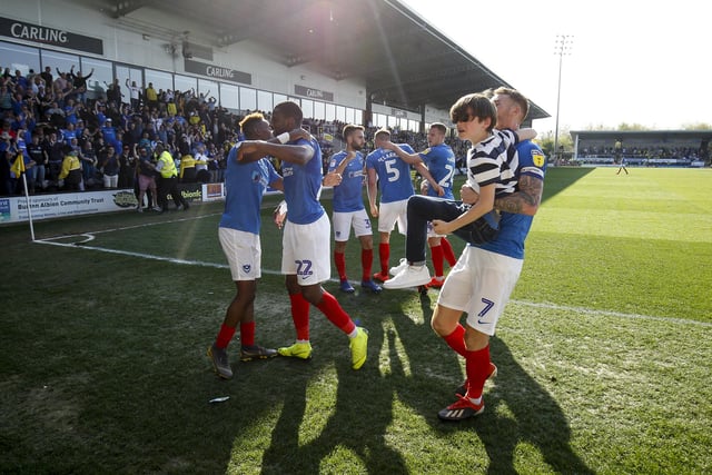 Tom Naylor carries a young Pompey fan off the pitch after celebrating