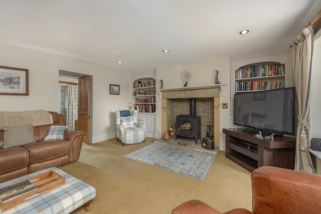 The comfortable lounge has a stone inglenook fireplace with a wood burning stove and leads to the rear hall.