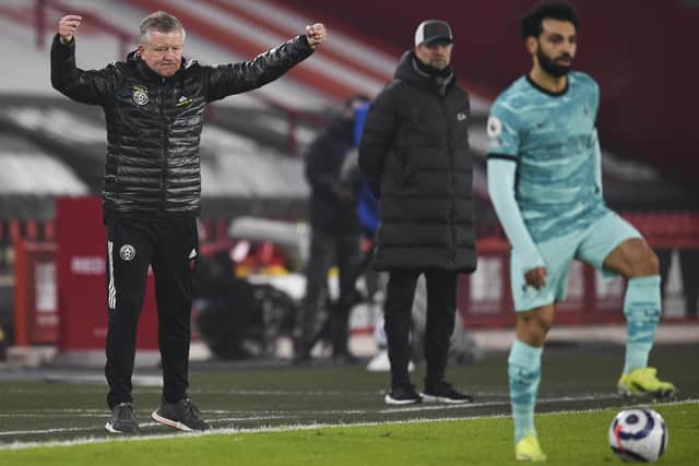 Sheffield United's manager Chris Wilder, left, and Liverpool's manager Jurgen Klopp, center, watch as Liverpool's Mohamed Salah plays the ball during the Premier League match between Sheffield United and Liverpool at Bramall Lane stadium in Sheffield, England, Sunday, Feb. 28, 2021. (Oli Scarff, Pool via AP)