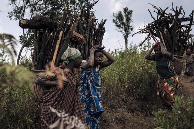 Displaced women carry firewood toward the internally displaced persons (IDP) camp of Bijombo - The photograph was taken at the exact spot where a woman and three girls were killed by militiamen returning from collecting firewood.