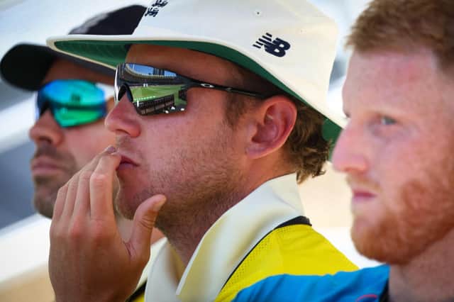 England's players Jimmy Anderson (L), Stuart Broad (C) and Ben Stokes look on during day four of the first Ashes cricket Test match between England and Australia at the Gabba (Photo by PATRICK HAMILTON/AFP /AFP via Getty Images)