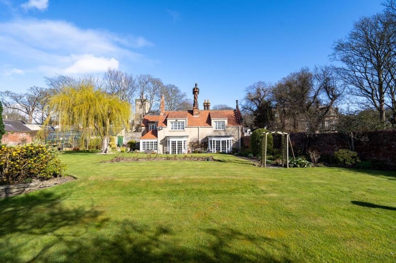 The stunning garden of the property which is accessed via a gated entrance that opens to a gravelled driveway leading to the house and garage.