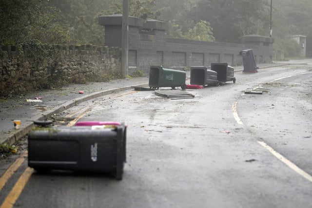 ROTHERHAM, UNITED KINGDOM - OCTOBER 23: Wheelie bins scatter the road as flood waters begin to recede in the village of Catcliffe after Storm Babet flooded homes, business and roads on October 23, 2023 in Rotherham, United Kingdom. The UK Environment Agency has warned that flooding could last for days in the wake of Storm Babet with 116 flood warnings remaining in place across England. (Photo by Christopher Furlong/Getty Images)