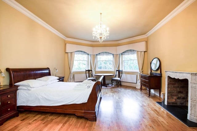 The main bedroom, which forms part of a master suite, has a  marble fireplace and a wide bay window offering fantastic views over the garden.