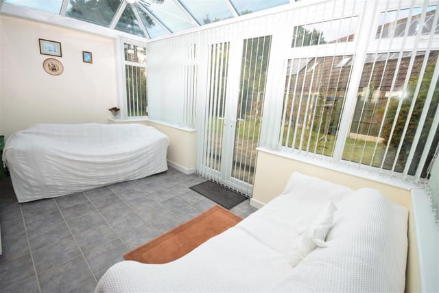 Although the seats are covered, this photo gives a good idea of how bright and airy the conservatory is. It is a versatile space with practical, tiled flooring and doors opening out to the back garden.
