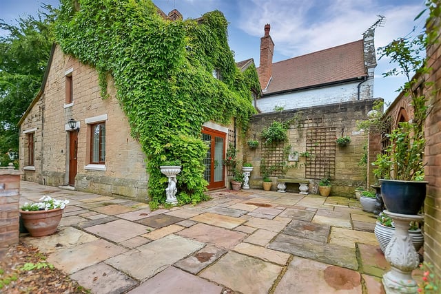 The private courtyard section of the garden has a stone patio and a high stone boundary wall with arched top gate that can provide access to the front.
