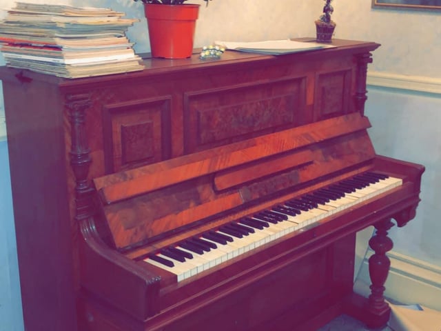 When was the last time this piano was played? Music books lay scattered on top.