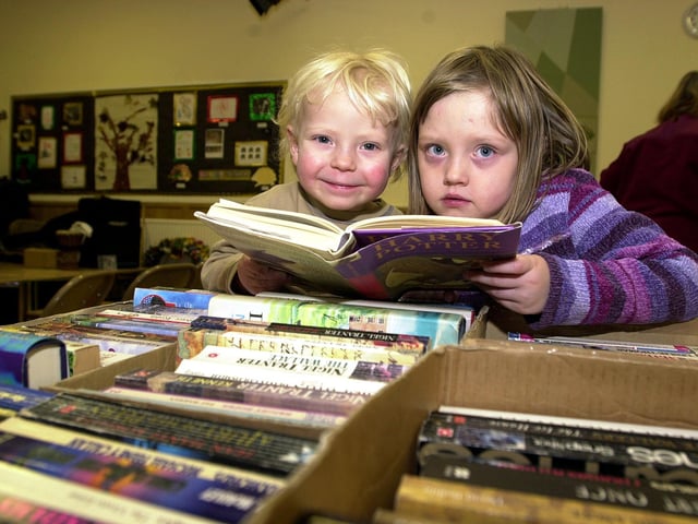 Brother and sister Asa and Ellie Kate Jones, aged three and six, pictured checking out a Harry Potter book at the Methodist Church Christmas Fayre, held in the schoolroom at Northgate, Tickhill, in 2003