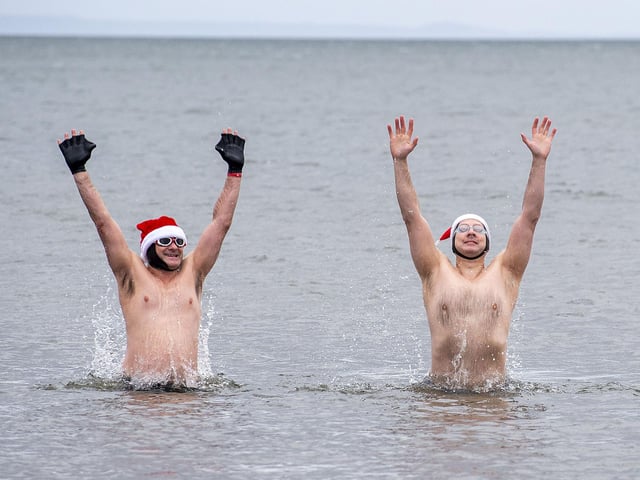 Christmas spirit kept high at Portobello Beach as swimmers Ross McNulty and Gareth Rudd celebrate braving the cold waters on December 25.