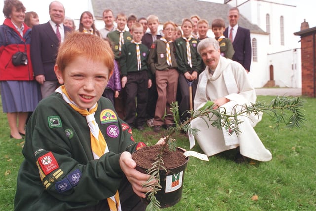 L to r: Lee White(10) with the sapling from a 2000 year old yew tree, pictured with members of the congregation  and Rev. John Richards, Rector of St. Peter's in 1999