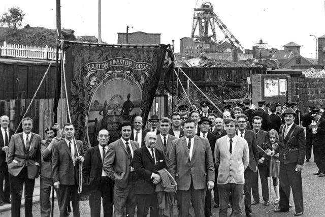 The banner of Harton and Westoe Miners' Lodge hangs high outside the empty buildings of Harton Colliery, closed almost a year ago.  Lodge officials and members pictured outside the former pit before marching to South Shields station on their way to the Durham Gala in July 1970.