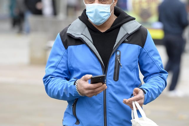 A solo shopper on Fargate wearing a face mask while out and about