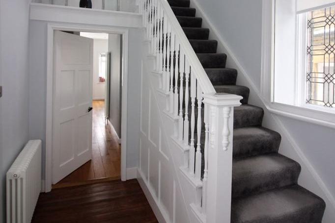 A spindled staircase with fitted carpet leads to the half-landing.