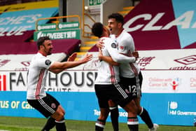 John Egan celebrates with his Sheffield United team mates after scoring a goal that would earn the Blades a point against Burnley at Turf Moor yesterday. (Photo by CLIVE BRUNSKILL/POOL/AFP via Getty Images)