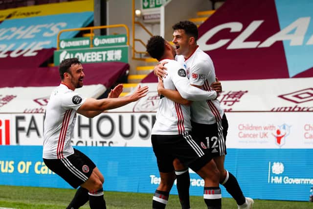 John Egan celebrates with his Sheffield United team mates after scoring a goal that would earn the Blades a point against Burnley at Turf Moor yesterday. (Photo by CLIVE BRUNSKILL/POOL/AFP via Getty Images)