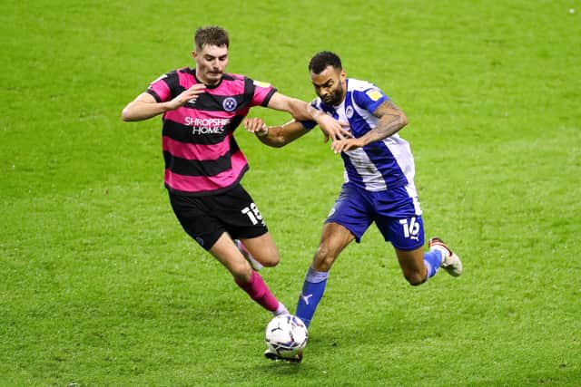 Curtis Tilt of Wigan Athletic battles for possession with Tom Bloxham of Shrewsbury Town during the Sky Bet League One match between Wigan Athletic and Shrewsbury Town at DW Stadium on December 08, 2021 in Wigan, England. (Photo by Lewis Storey/Getty Images)