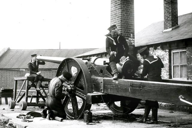 Naval ratings at Portsmouth cleaning up a gun which has its original wood carriage that was used by the Royal Navy in the 100-mile trek to the relief of Ladysmith during the South African War, 3rd April 1935. This naval gun will be hauled round Olympia during the Royal Tournament. (Photo by Topical Press Agency/Hulton Archive/Getty Images)