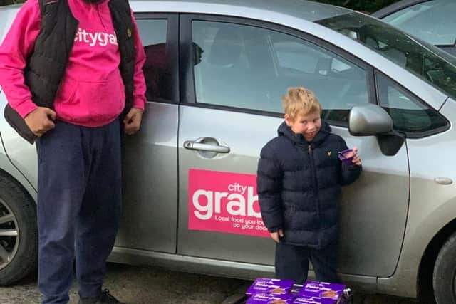 A grateful Lucas Croxall with Citygrab driver Mohammed Razwan who delivered more than 200 Cadbury Pots of Joy desserts to the youngster's home in Stannington, Sheffield after Lucas' mother Jane issued a desperate appeal