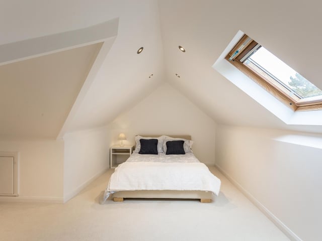 This bedrooms has a skylight and spotlights.