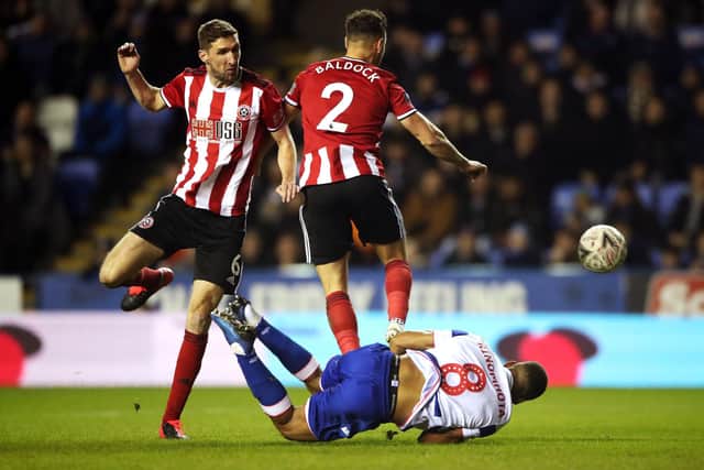 Reading's Andy Rinomhota (floor) goes down inside the box after being tackled by Sheffield United's Chris Basham (left) and George Baldock, resulting in a penalty, during the FA Cup fifth round match at the Madejski Stadium: Nick Potts/PA Wire.