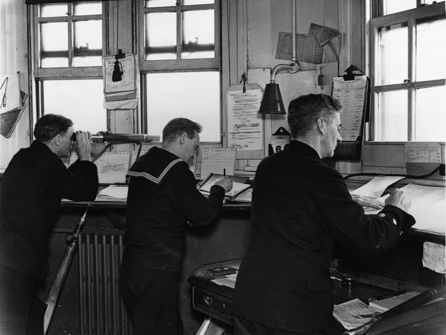 1940:  Sailors at the Central Signal station, Portsmouth, southern England, during WW II. One is using a telescope.  (Photo by Central Press/Getty Images)
