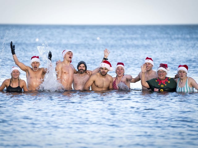 People swim and take a dip in the Firth of Forth at Portobello Beach in Edinburgh on New Year's Day. Picture date: Saturday January 1, 2022. PA Photo. Photo credit should read: Jane Barlow/PA Wire
