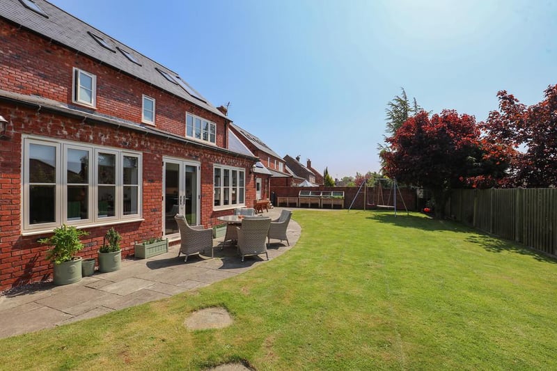 The property has landscaped gardens with lawn, patio and seating area.