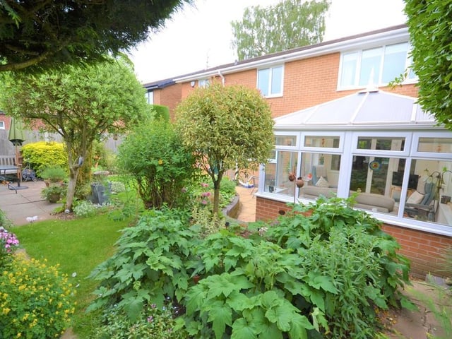 Rear garden - Wrought iron gates to either side of the property give access to a fully enclosed and private rear garden, having mature trees, shrubs and flowers frame various patio seating areas and well kept lawn, there is access back into the breakfast room and conservatory.