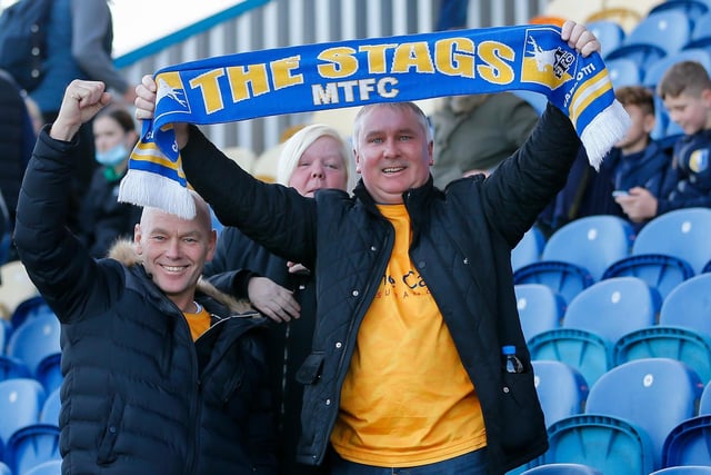 Mansfield Town fans watch their team win at home against Scunthorpe Utd.