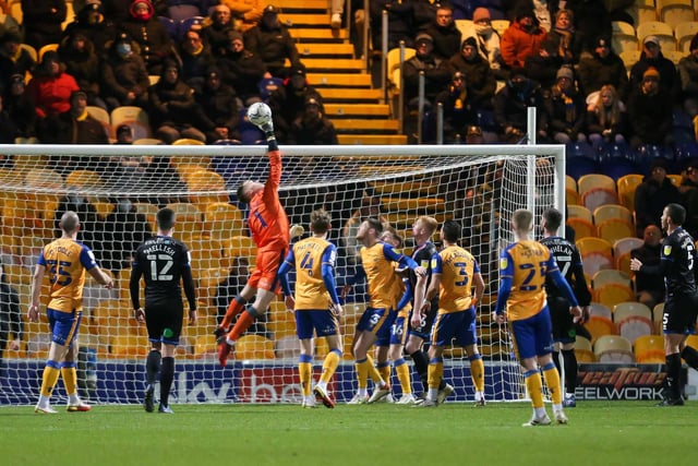 Mansfield Town goalkeeper Nathan Bishop makes a save to stop Harry Charsley's clearance dropping into his own net.