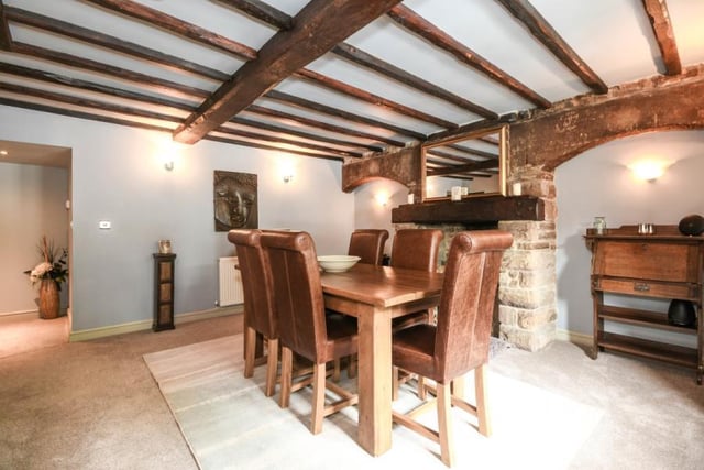 A stunning feature stone fireplace and ceiling beams are the focal points of the dining room which has doors opening onto the back of the property.