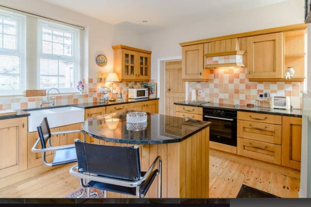The kitchen is extensively fitted with a range of units, a central island with an integral breakfast bar, black granite worktops, a double butler sink, and integrated appliances.

Picture: Right Move