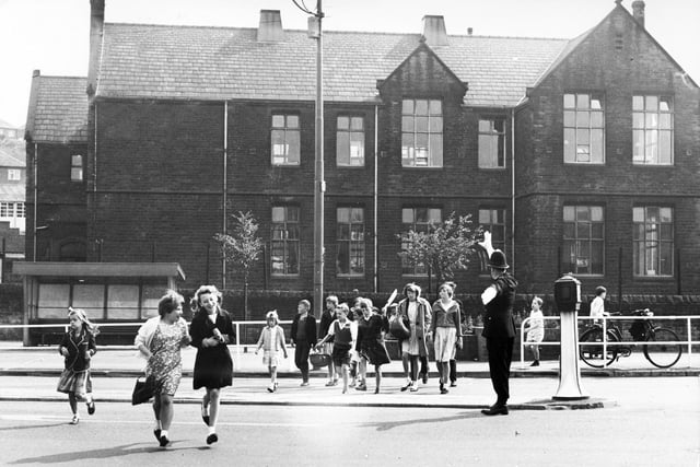 Children scamper home from school at Owler Lane with the help of a policeman,  July 1964