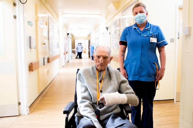 Former guardsman Albert Chambers with Nurse Paige Lax. Mr Chambers, who survived three years in a German prisoner of war camp has been clapped out of hospital after recovering from Covid-19. Photo: NHS