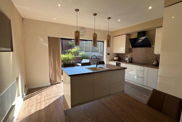 The kitchen island doubles as a breakfast bar, offering useful storage space and looking onto both the dining area and garden.