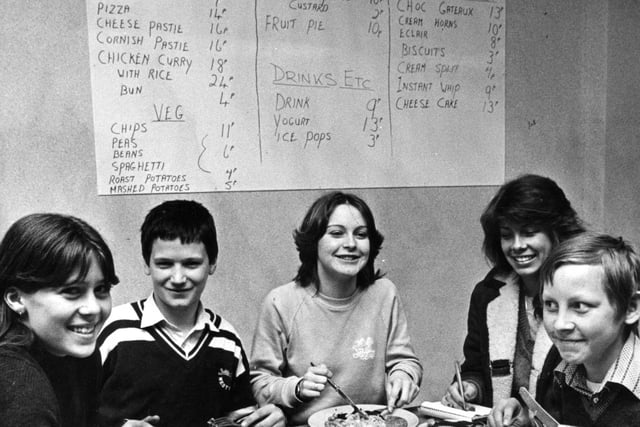 Look at the dinnertime bargains at South Shields Comprehensive School. Chicken curry with rice for 42 pence and pizza and chips for 25 pence!
Pictured at the dining table are left to right  Dawn Fada, George Scorer, Angela Scott and Thomas Rear.  Reporter Diane Rose is pictured taking notes in 1981.