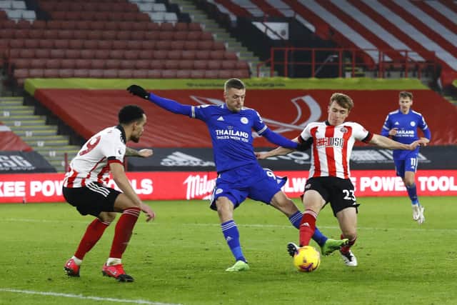 Jamie Vardy of Leicester City is challenged by Ben Osborn (R) of Sheffield United (Photo by Jason Cairnduff - Pool/Getty Images)