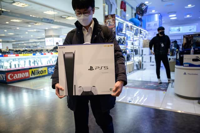A customer walks away after purchasing the new Sony PlayStation PS5. (Photo by ED JONES/AFP via Getty Images)