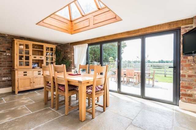 The open plan kitchen diner offers plenty of room for both family meals and entertaining guests, with the dining table overlooking the gardens.