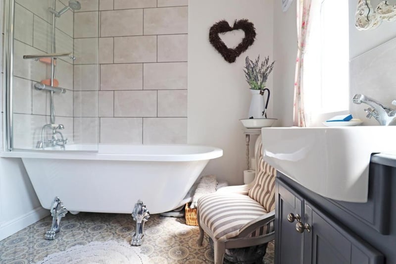 The white roll top bath adds a vintage feeling to the bathroom.