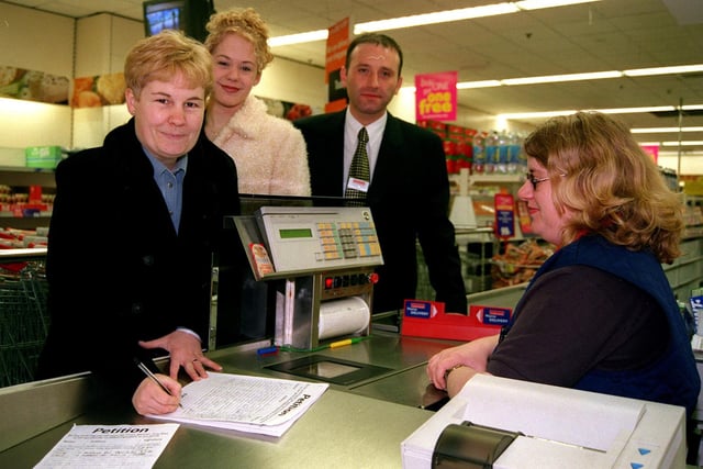 Jackie and Jessica Jackson  sign a petition  against GMO foods at Crystal Peaks Iceland  Store manager David Sharp  and cashier Dawn Webster looked on in 1999